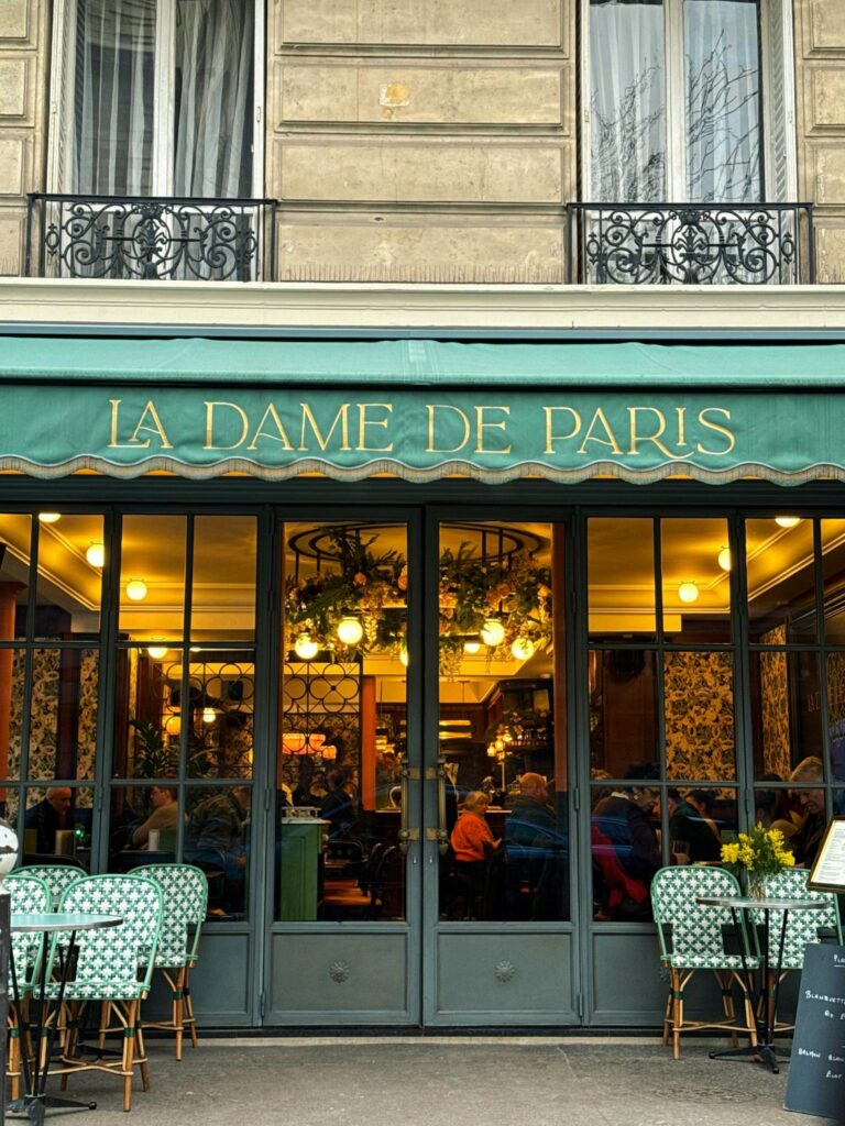 Inviting entrance of La Dame de Paris café showcasing classic French elegance.