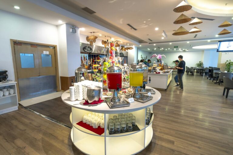 Spacious hotel buffet area with a variety of drinks and seating arrangements.